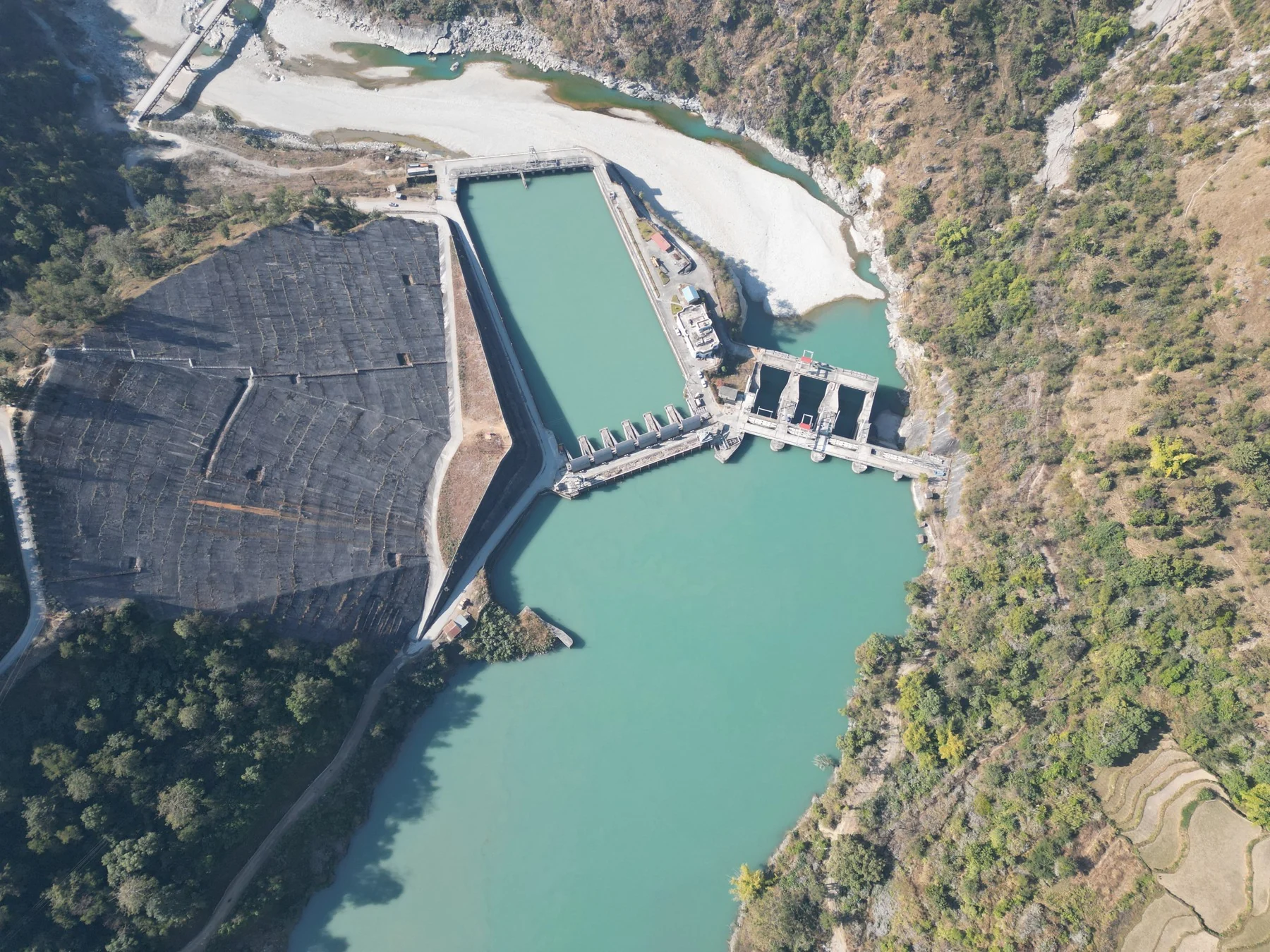 Hydropower intake basin beside a river in a steep mountain valley in Nepal