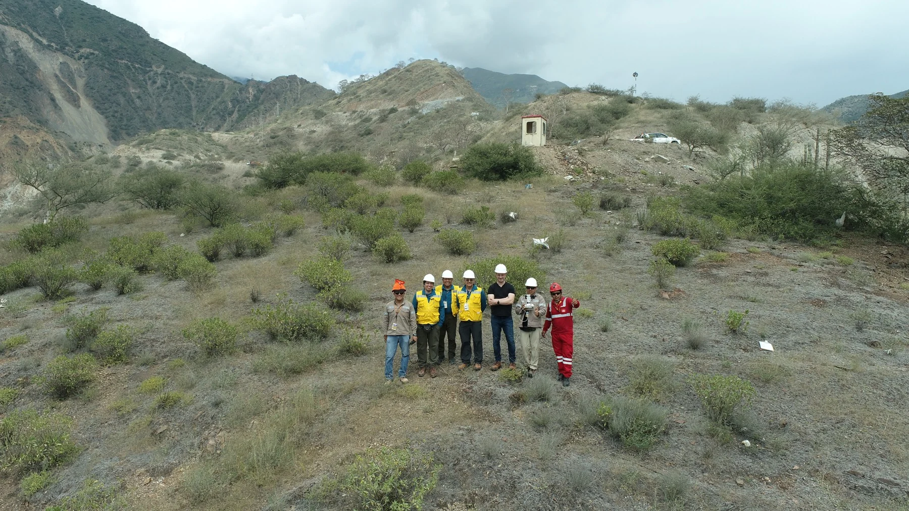 Project team wearing safety helmets and high-visibility vests at a site in the Peruvian Andes